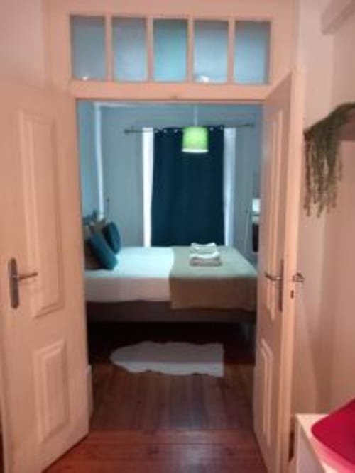 Bedroom entrance in Lisbon apartment with bed, window views, and modern furnishings at Charm Discovery Experiences