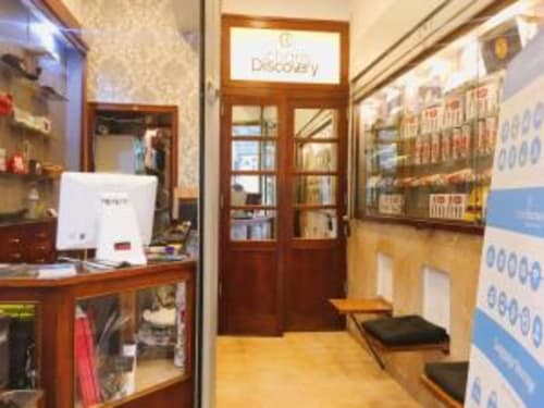 Charm Discovery Experiences B&B reception area in Lisbon with wooden doors, front desk, and hardwood floors
