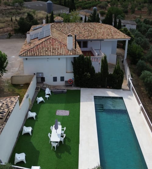 Vista aérea de la Casa Rural Finca El Olivar con tejado de barro, piscina privada y jardín artificial