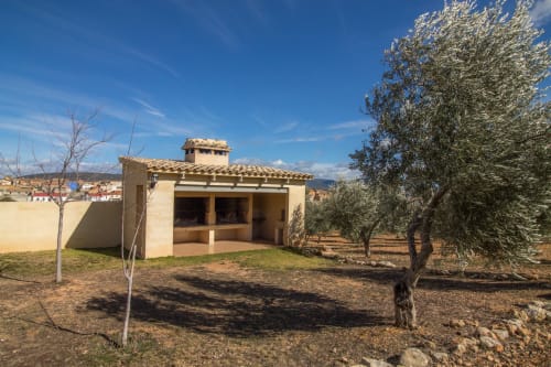 Casa Rural Finca El Olivar cottage with terracotta roof, stone walls, olive trees, and countryside views in Las Cuevas,
