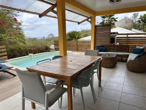 Terrasse piscine de la villa Goyave aux Exotic Villas Martinique avec table à manger, salon et vue sur mer
