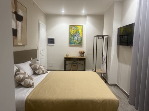Camera da letto moderna e doppia BellDuomo Suite Messina con biancheria beige, scrivania, opere d'arte, TV e arredamento minimalista