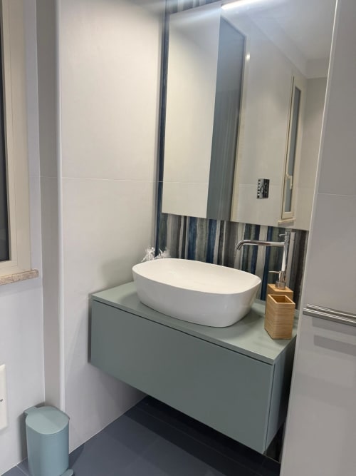 Vanità da bagno moderna con lavabo ovale bianco, mobile verde chiaro e grande specchio della suite BellDuomo Messina