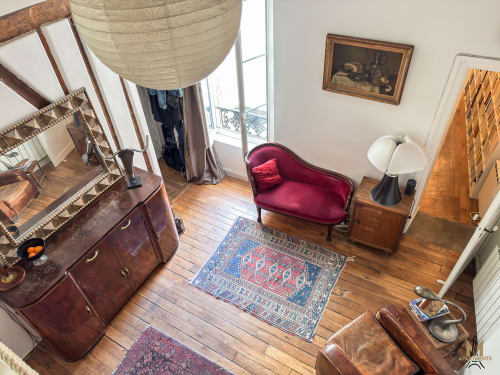 Studio Montmartre Del Sarte avec canapé en velours bordeaux, mobilier en bois et parquet à Paris