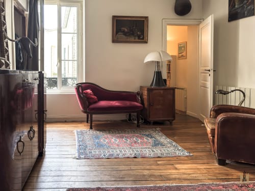 Élégant salon dans l'appartement Del Sarte aux Apartments Montmartre, Paris avec canapé en velours bordeaux et mobilier d'époque