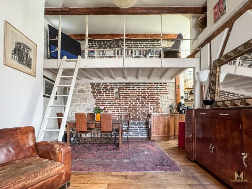 Appartement Del Sarte à Montmartre, Paris avec briques apparentes, mezzanine, sièges cuir et mobilier bois