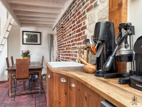 Cuisine de l'appartement Del Sarte aux Apartments Montmartre Paris, avec briques apparentes, comptoirs en bois et cafetière