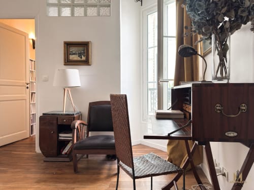 Coin salon de l'appartement Del Sarte aux Appartements Montmartre Paris, avec bureau en bois, chaise, lampe et mobilier d'époque