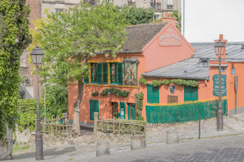 Charmant bâtiment orange aux volets verts à Montmartre Paris, avec architecture historique et murs de brique couverts de lierre
