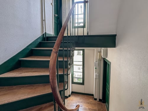 Escalier en spirale aux marches en bois et rampes vertes dans les Appartements Montmartre à Paris