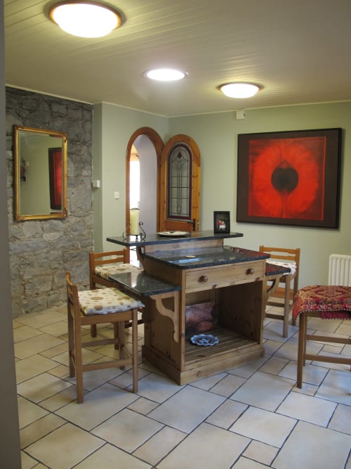 Knockaderry House dining room in Ennis with wooden furniture, slate fireplace, and modern artwork