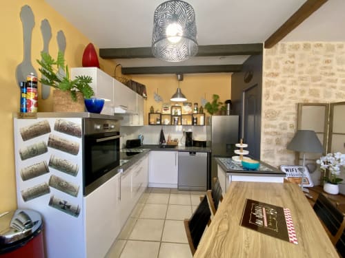 Cuisine moderne du gîte Le Cocon Boheme à Ô Clair De Lune, Sarlat avec meubles blancs, appareils inox et