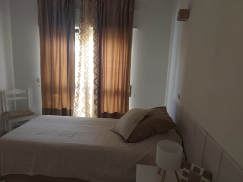 Quarto aconchegante no Albufeira Inn com cama, cortinas marrons, cortinas translúcidas estampadas e paredes brancas no Edifício Elimar 1