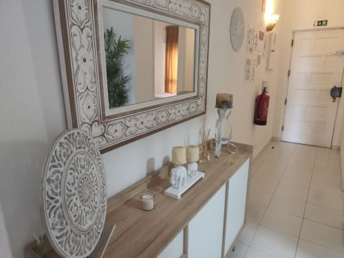 Entrada do Albufeira Inn com espelho decorativo, console em madeira e arte de parede ornamental branca
