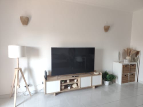 Sala de estar moderna no Albufeira Inn com TV de ecrã plano, móveis em madeira, luminária de pé e decoração minimalista