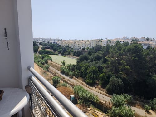 Vista da varanda da Albufeira Inn com jardins exuberantes, campos verdes e edifícios residenciais em Albufeira, Portugal