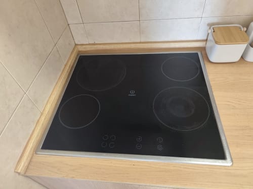 Fogão de indução preto com quatro queimadores na cozinha do apartamento T1 Albufeira Inn, Edifício Elimar 1