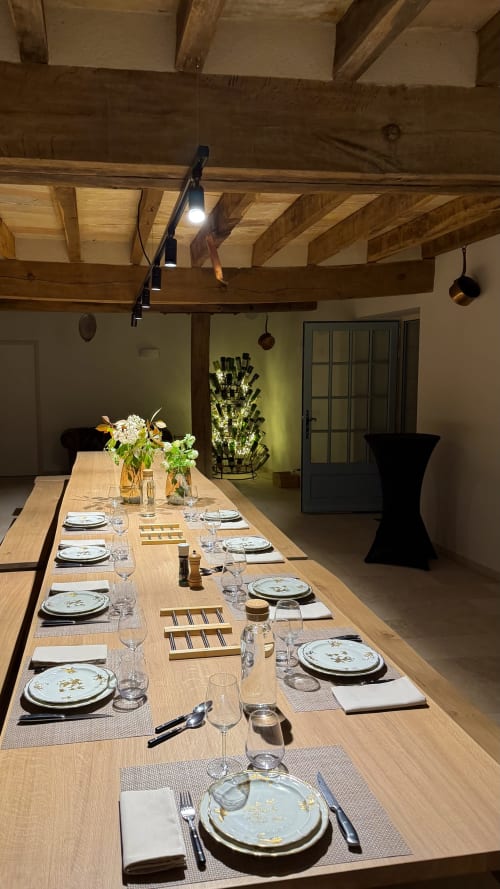Table de salle à manger élégamment dressée pour les hôtes du gîte Cloffy à Nouans-les-Fontaines, avec poutres apparentes et bouquet floral