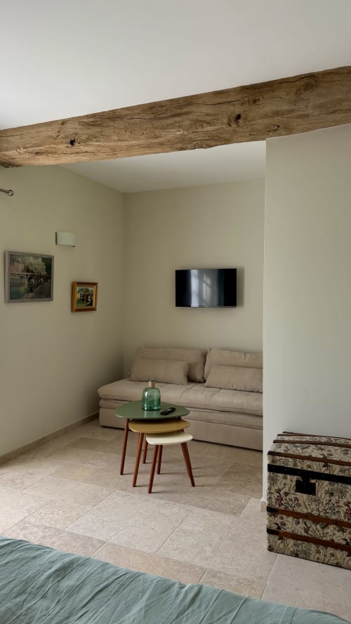 Séjour du cottage Cloffy à Nouans-les-Fontaines avec poutre apparente, canapé beige et TV murale