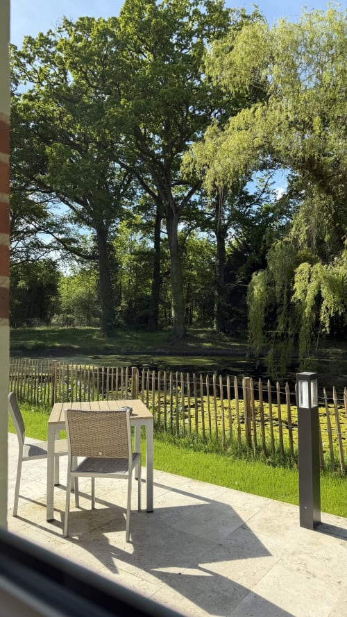 Coin salon sur la terrasse avec vue sur le lac paisible du gîte Cloffy à Nouans-les-Fontaines, France
