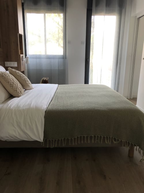 Bright bedroom with queen bed, garden view doors, and modern amenities at Les clés d'à côté guesthouse near Rouen