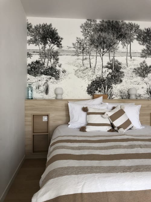 Dormitorio de Les clés d'à côté cerca de Rouen con cama a rayas, almohadas decorativas y paisaje de playa en blanco y negro