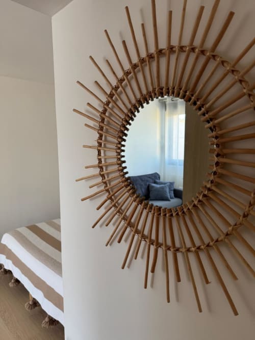 Espejo decorativo de madera en forma de sol que refleja el dormitorio con sillón azul en Les clés d'à côté, Rouen