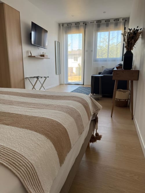 Habitación moderna en Les clés d'à côté cerca de Rouen con vistas al jardín, TV, escritorio y mobiliario contemporáneo