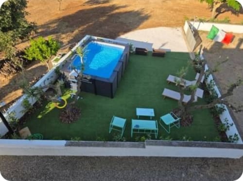 Aerial view of Dimora Pierino villa garden in Martina Franca with pool, loungers, and Italian flag