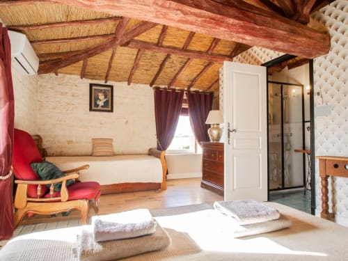 Chambre Bordeaux à L'Ecrin des Roches, Le Langon : chambre rustique aux poutres apparentes, accents rouges, salle de bain moderne