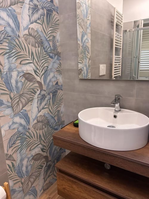 Bagno moderno dell'Anima Est B&B Napoli con lavabo in ceramica bianca, doccia con piastrelle botaniche e mobile in legno