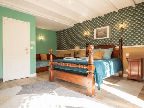 Chambre Verte Deluxe au gîte L'Ecrin des Roches avec lit à baldaquin en bois, murs verts, papier peint à motifs