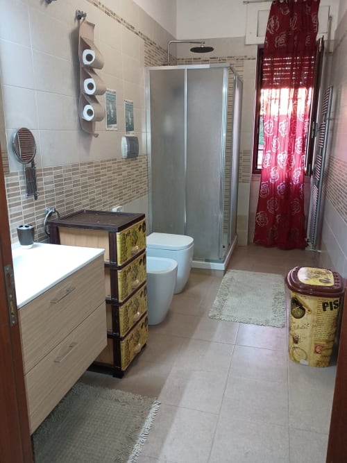 Moderno bagno della Camera Sophie in B&B S HOME Napoli con lavabo, toilette, doccia e tende rosse