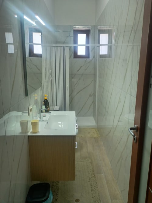Bagno moderno in Camera Sophie presso B&B S HOME, Napoli con piastrelle in marmo, lavabo bianco e cabina doccia in vetro