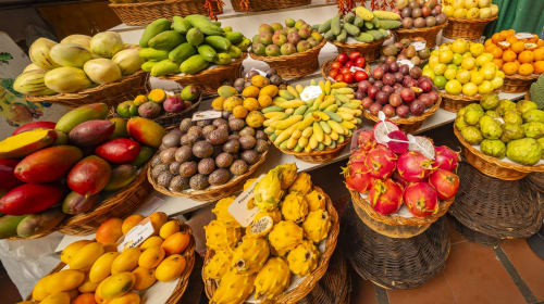 Exposição colorida de frutas tropicais no mercado do hotel Madeirarooms em Funchal, Portugal, incluindo mangas, bananas e frutas locais