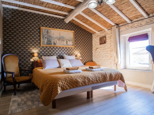 Chambre Deluxe luxueuse à L'Ecrin des Roches B&B au Langon avec papier peint motifs, poutres bois et élégance