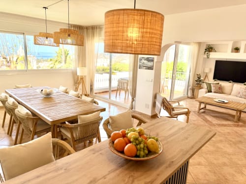 Interior de villa moderna en Nerja con comedor, vistas al mar, mobiliario de madera y luz natural