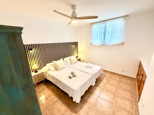 Dos camas individuales con sábanas blancas en luminosa habitación de Villa Sienna, Nerja Holiday Homes, con ventilador moderno y vistas al mar