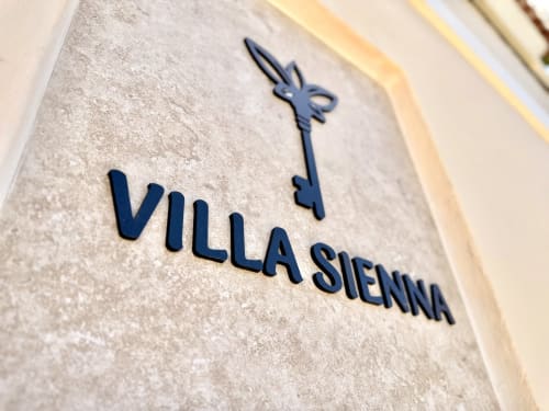Letrero de Villa Sienna con escudo decorativo en la pared de entrada de Nerja