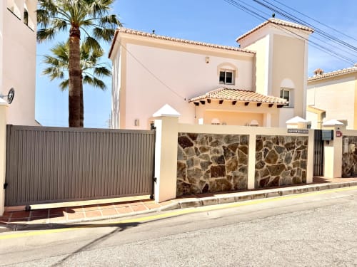 Villa Sienna en Nerja - encantadora villa mediterránea con fachada color crema, entrada de piedra, palmera y diseño moderno