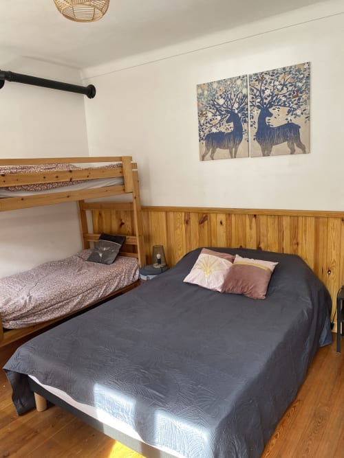 Chambre cosy du gîte L'encabanée avec lit superposé, lit queen-size, lambris bois et décoration cerf