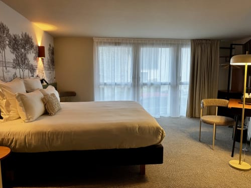 Suite luxe lit king à l'Hôtel des Quatre Saisons à Guérande, décor moderne, baies vitrées, élégance