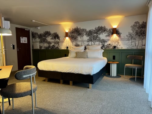 Suite luxe avec lit king au Hôtel des Quatre Saisons à Guérande, fresque paysagère et éclairage chaleureux