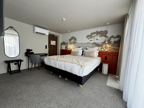 Chambre luxe avec lit king-size à l'Hôtel des Quatre Saisons à Guérande, décor moderne, fresque nature et mobilier élégant