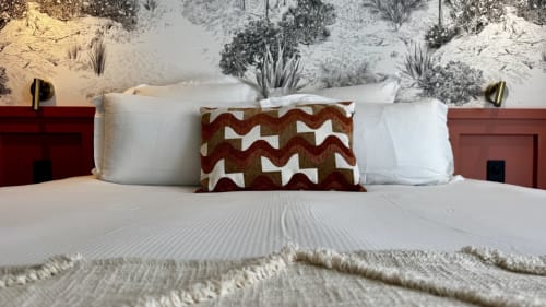 Lit king luxueux avec coussin aux motifs rouille et crème à l'Hôtel des Quatre Saisons à Guérande, France
