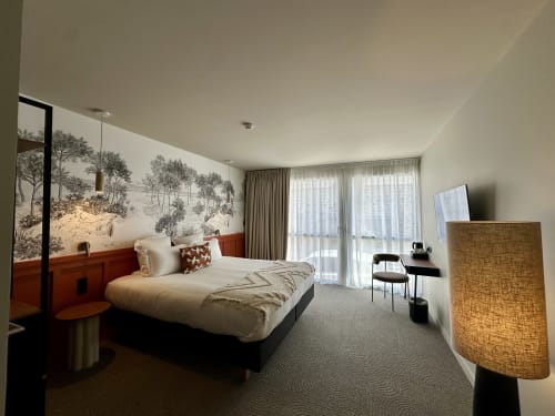 Luxueuse chambre royale à l'Hôtel des Quatre Saisons à Guérande avec œuvres d'art, mobilier moderne et accès au balcon