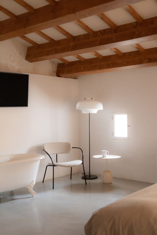 Minimalist hotel room at Hotel Fragile in Menorca with exposed wooden beams, modern furniture, and natural light