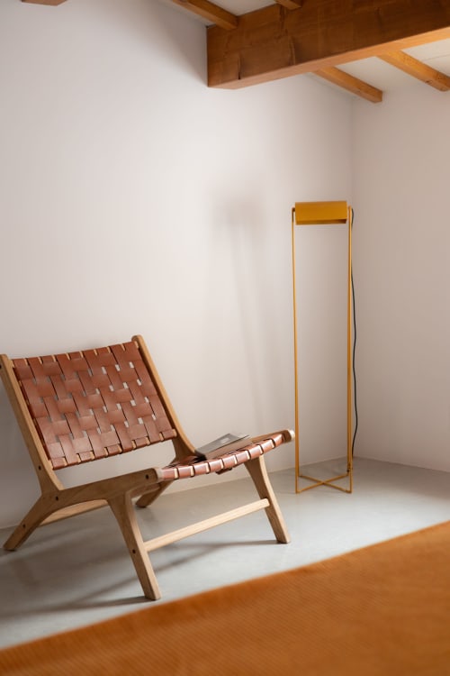 Minimalist hotel room at Hotel Fragile in Menorca featuring woven leather chair and wooden room divider