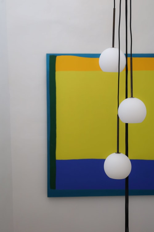 Colorful modern art installation at Hotel Fragile in Menorca featuring geometric shapes and hanging white spheres