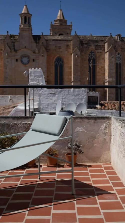 Rooftop lounge chair at Hotel Fragile overlooking historic cathedral in Ciutadella de Menorca